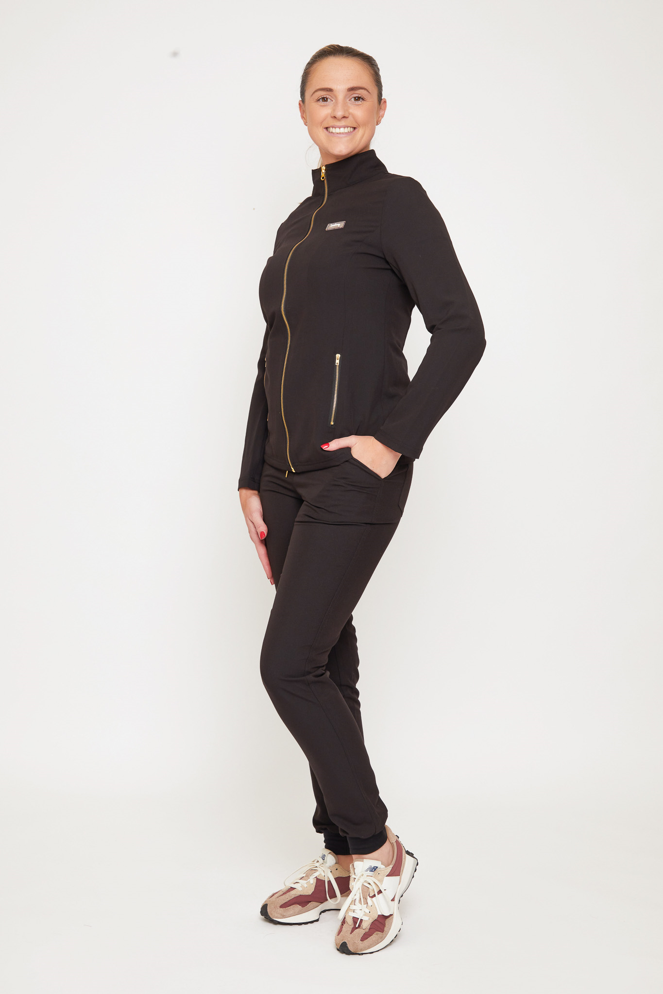 Woman wearing stylish black scrubs for beauty clinics in the UK
